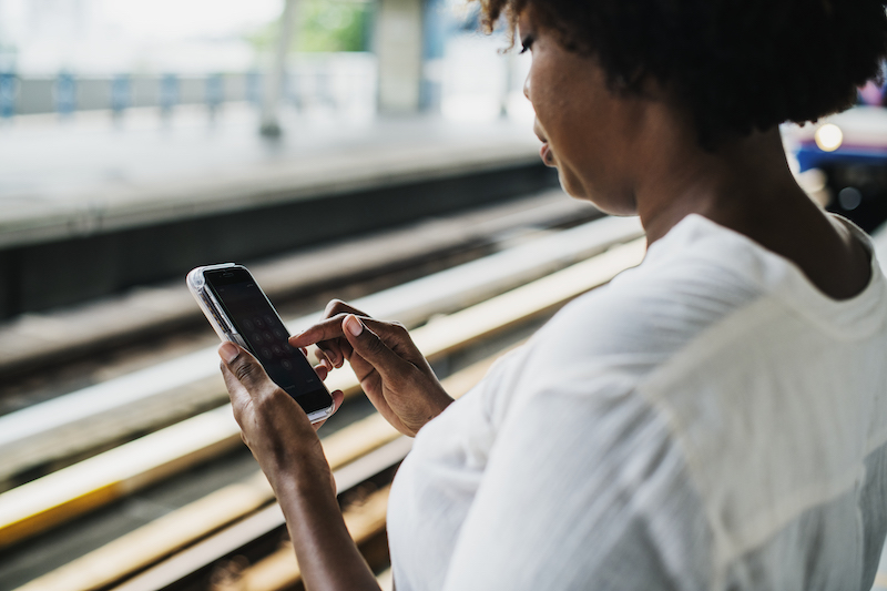 Woman waiting and playing on her phone