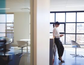 Businesswoman texting with cell phone in office